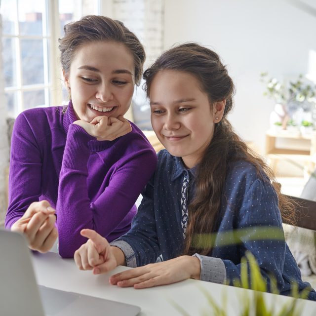 joyful-happy-young-mother-and-daughter-shopping-online-using-laptop-pc-sitting-at-desk-in-light-bedroom-interior-pointing-fingers-at-screen-and-smiling-640x640