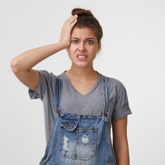 stressful-woman-denim-overall-clutched-her-head-panic-640x640